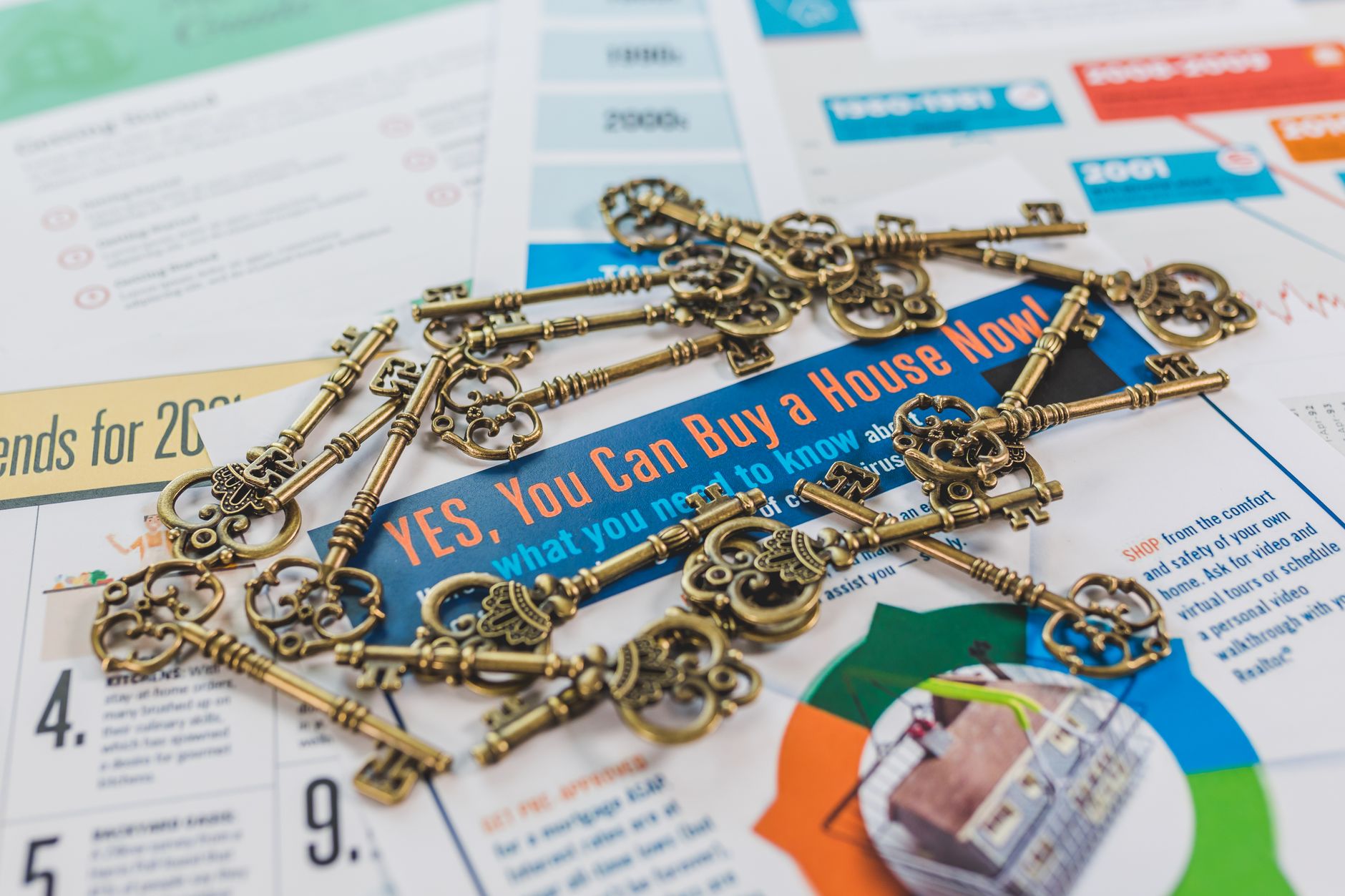 bunch of vintage keys on top of colored catalogs